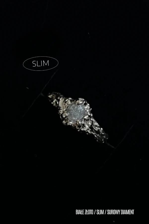 Pierścionek slim z białego złota 585 z osadzonym surowym diamentem.